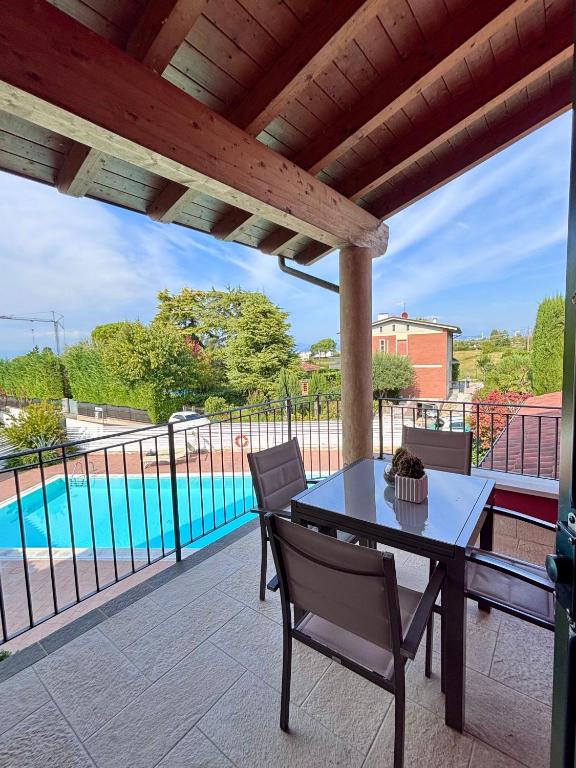 a table and chairs on a patio with a pool at Lazise Suite in Lazise