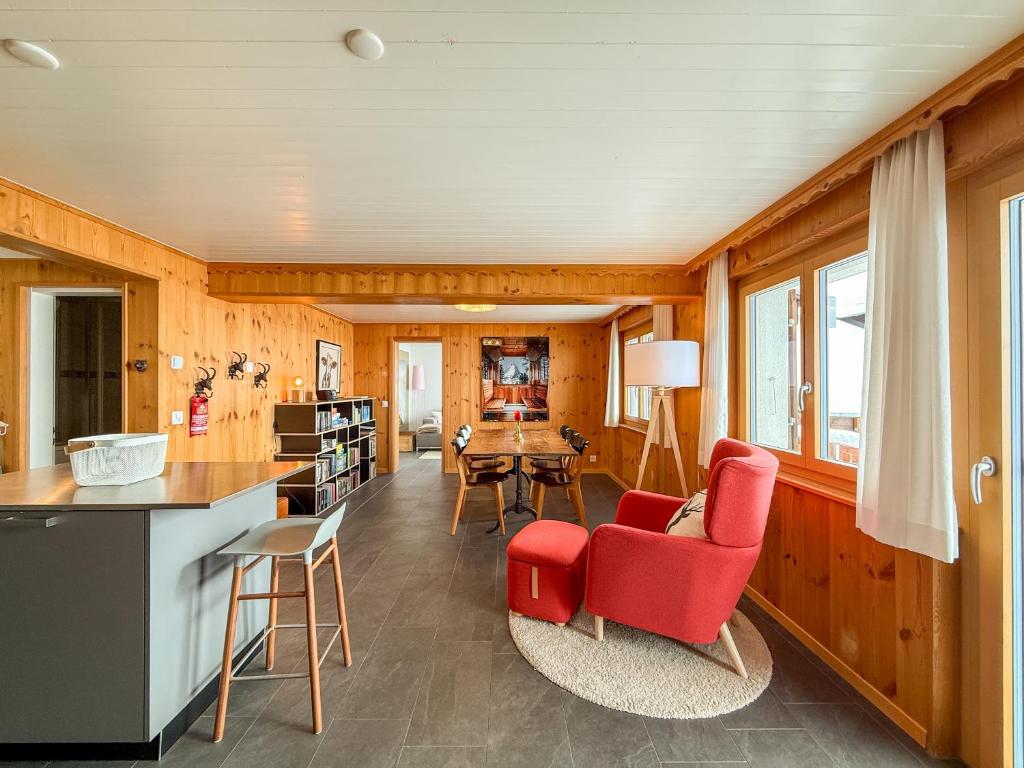 a living room with red chairs and a table at Chalet apartment with Mountain View in Bettmeralp