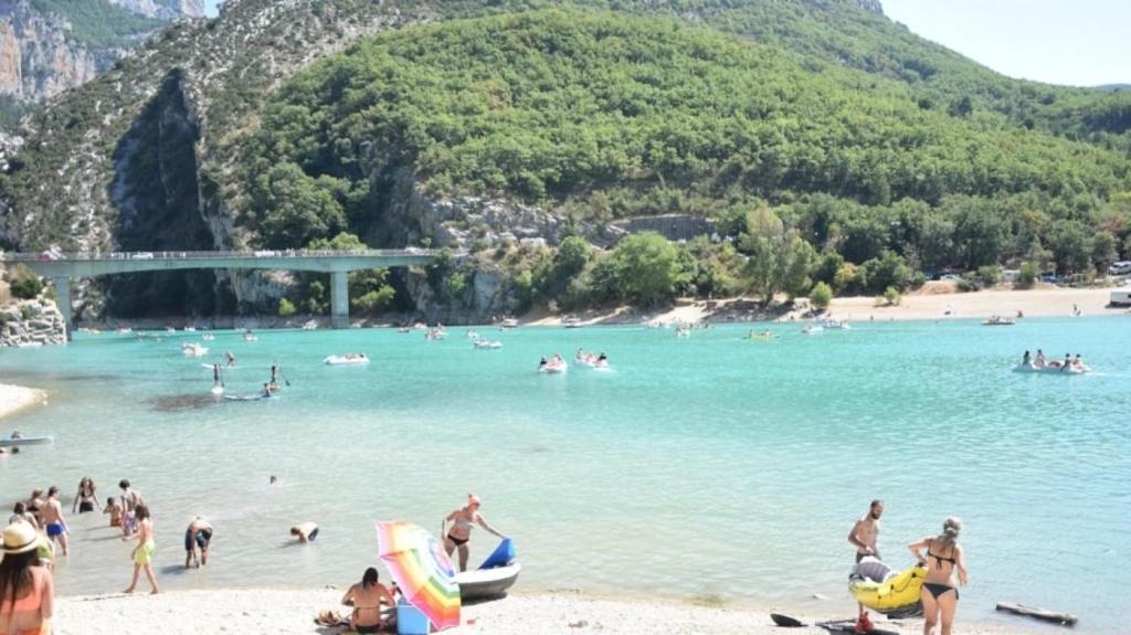 a group of people on a beach in the water at ZEcamping 3 étoiles animations à 2 km du lac de Sainte Croix in Moustiers-Sainte-Marie