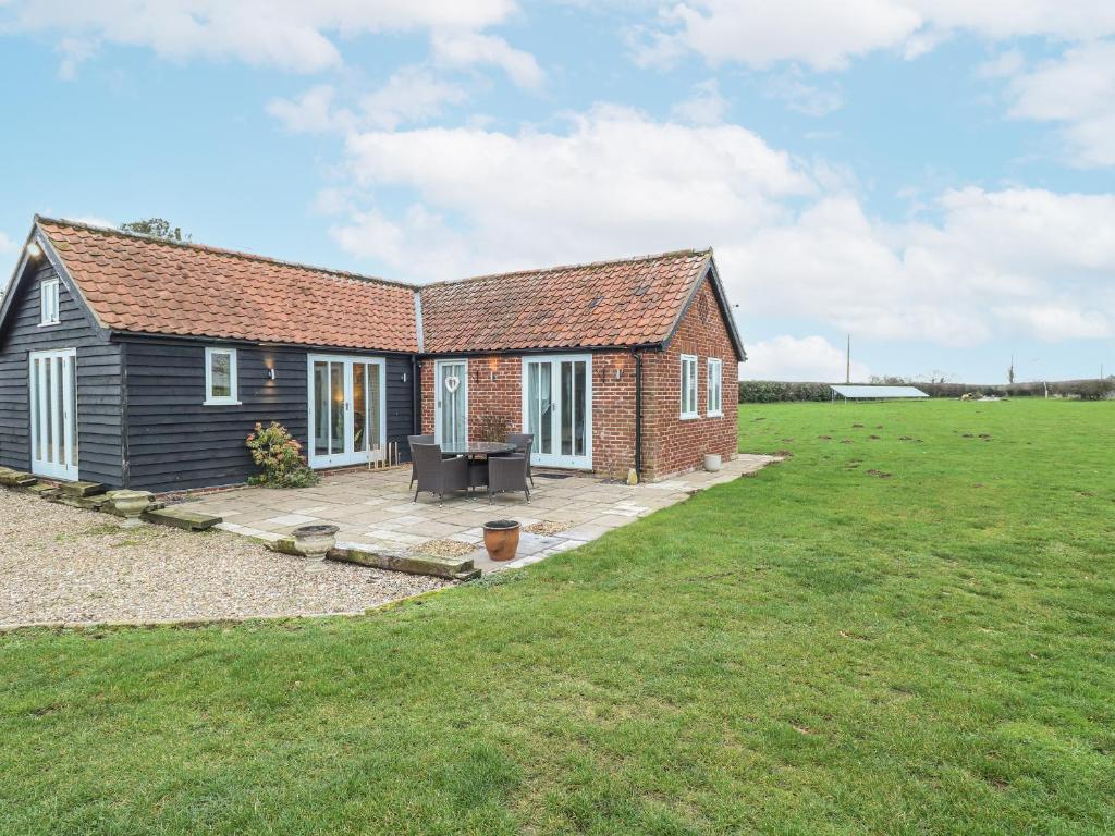 a small red brick house with a large yard at Ivy Barn in Norwich