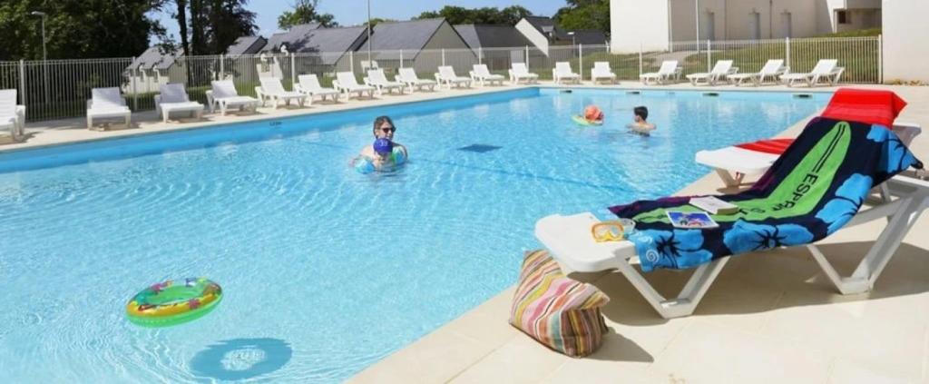a woman laying on a beach chair in a swimming pool at ZEcamping 3 étoiles pet friendly piscine chauffée et piscine couverte in Audierne