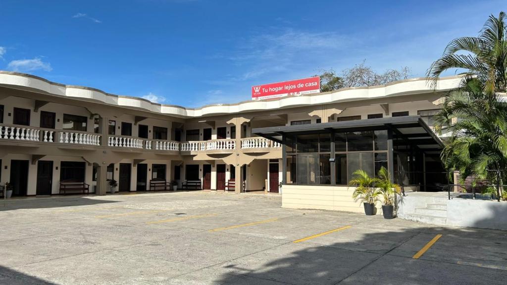 a hotel with a parking lot in front of it at Hotel Wilson Anexo in Liberia