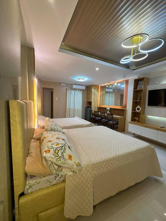 a bedroom with a large bed and a television at CEEJ Building Transient Studio Rooms in Iloilo City