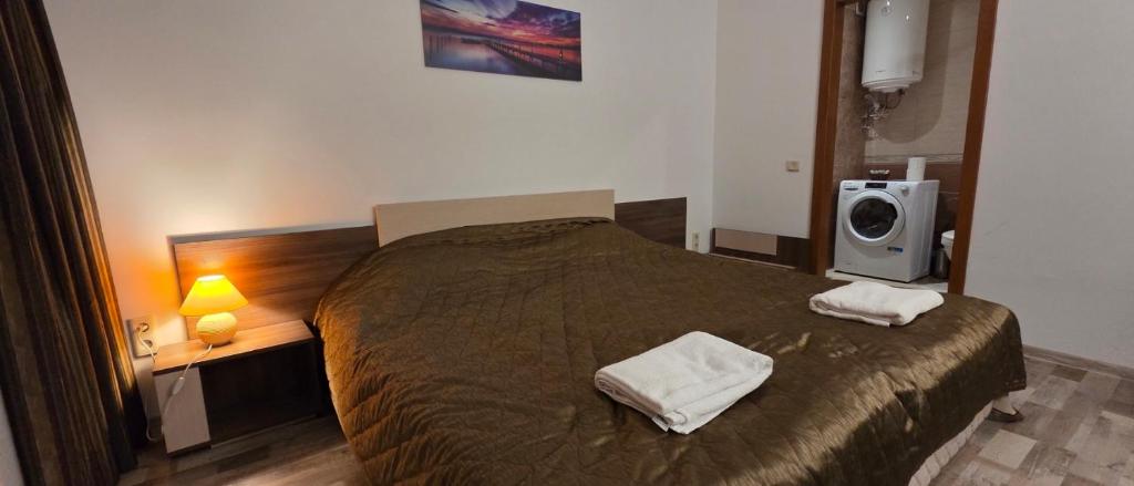 a bedroom with a bed with two towels on it at НАРцис in Bŭnzareto