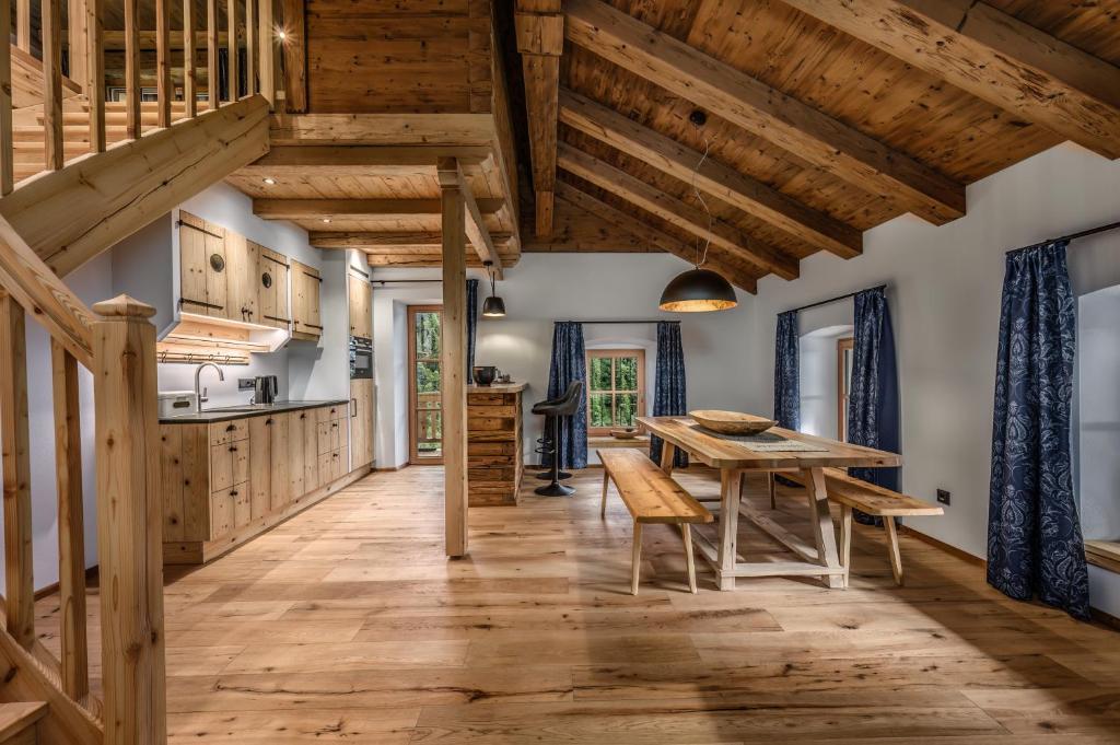 a kitchen with wooden ceilings and a wooden table and chairs at Ascherhof in Thiersee