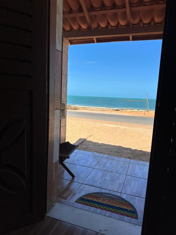 an open door to the beach with a view at Sereia beach chalé in Icapuí