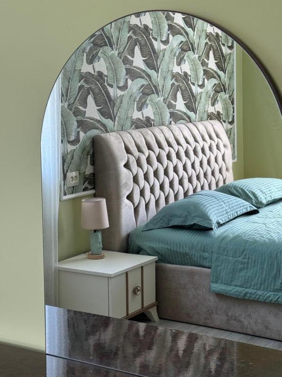 a bedroom with a large bed and a table with a lamp at Mamuka Guesthouse in Udabno