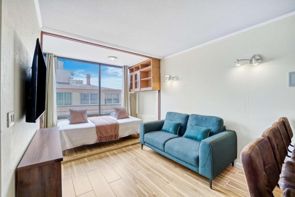 a living room with a blue couch and a bedroom at Espacio Viña- 1D with Wifi in Viña del Mar