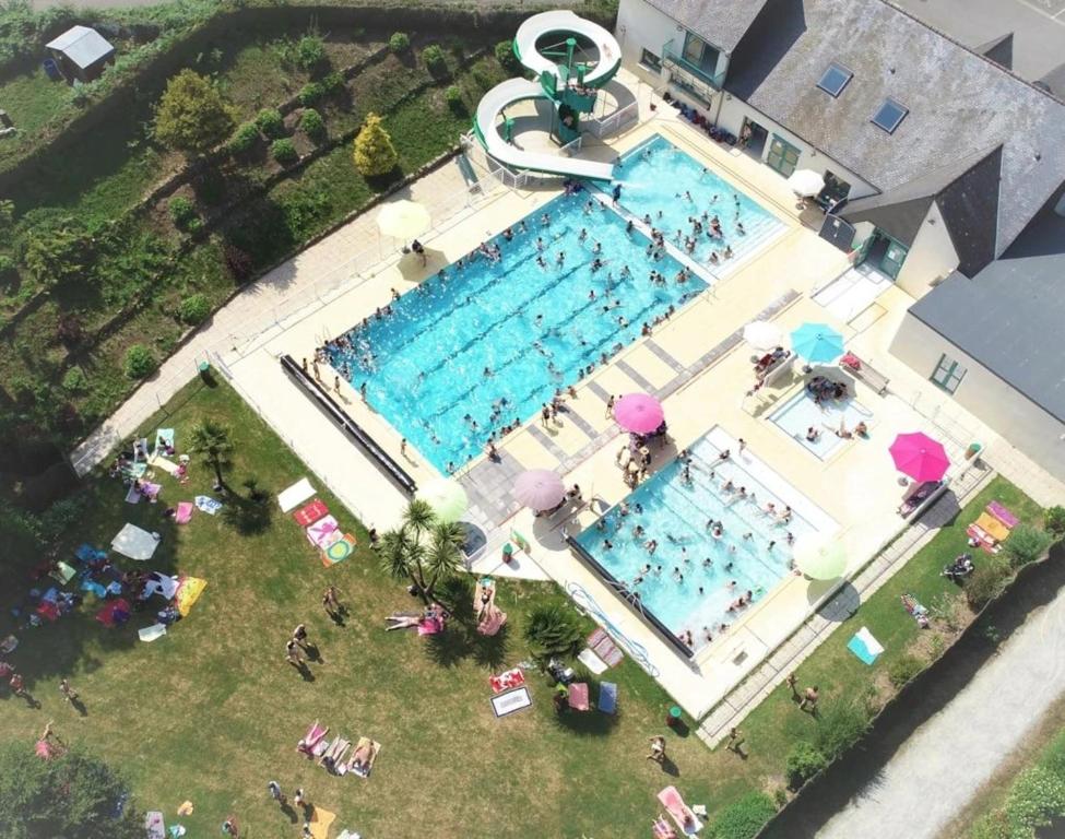 an overhead view of a large swimming pool with people around it at ZEcamping 3 étoiles pet friendly animations piscine chauffée in Merdrignac