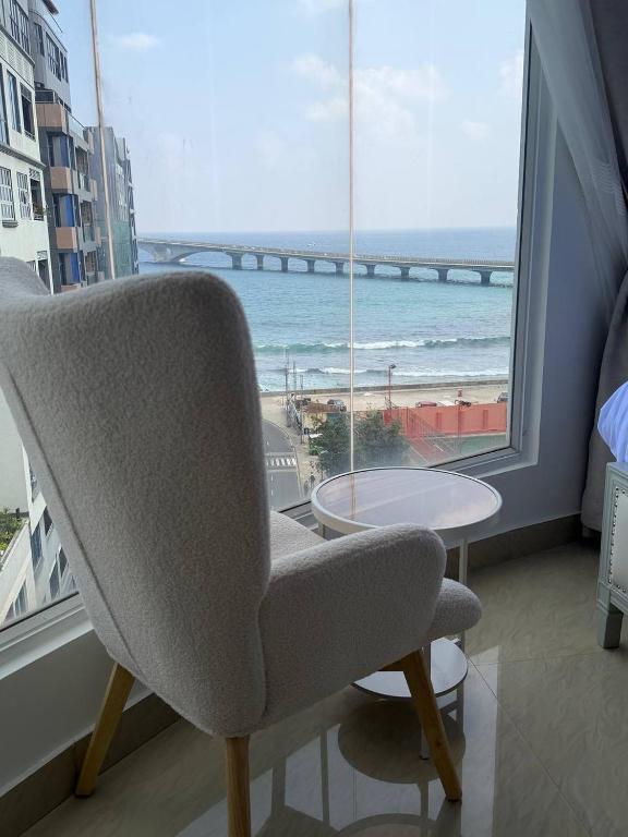 a chair in a room with a view of the ocean at Park View Stay in Male City