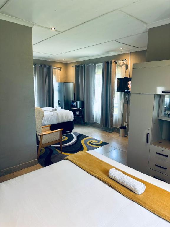 a hotel room with a bed and a television at Elegant guest house in Matsapha