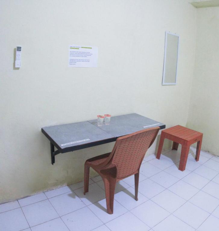 a blue table and a chair and a table and bench at Wisma Dahlia in Maumere