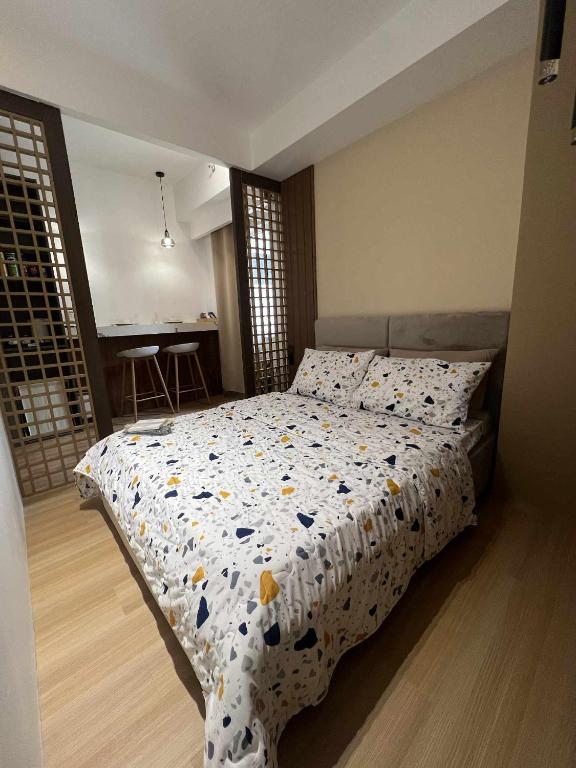 a bedroom with a bed with a comforter on it at SMDC Cheer residences-ZKL SUITES in Marilao