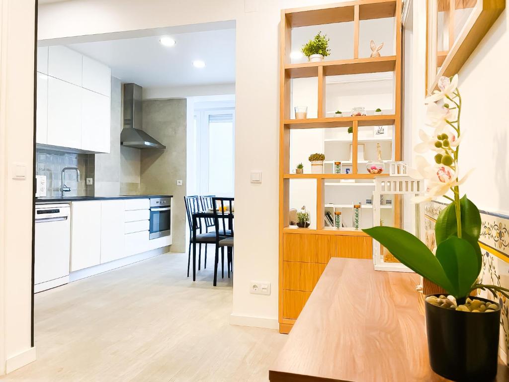 a kitchen and dining room with white cabinets at Modern 3 Bedroom Apartment Near Belém Lisbon Upto 5 Guests in Cruz Quebrada
