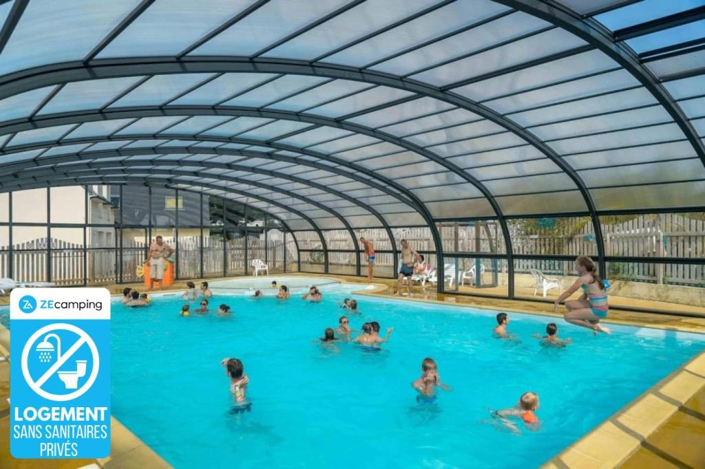 a group of people in a swimming pool at Chalet 3 étoiles - Piscine - ccbbhfa in Clohars-Carnoët