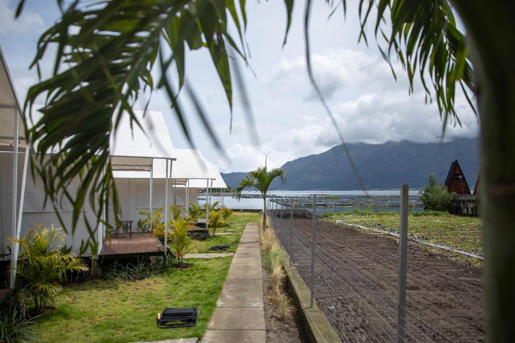 a fence in front of a house next to a body of water at Ohara Glamping in Kubupenlokan