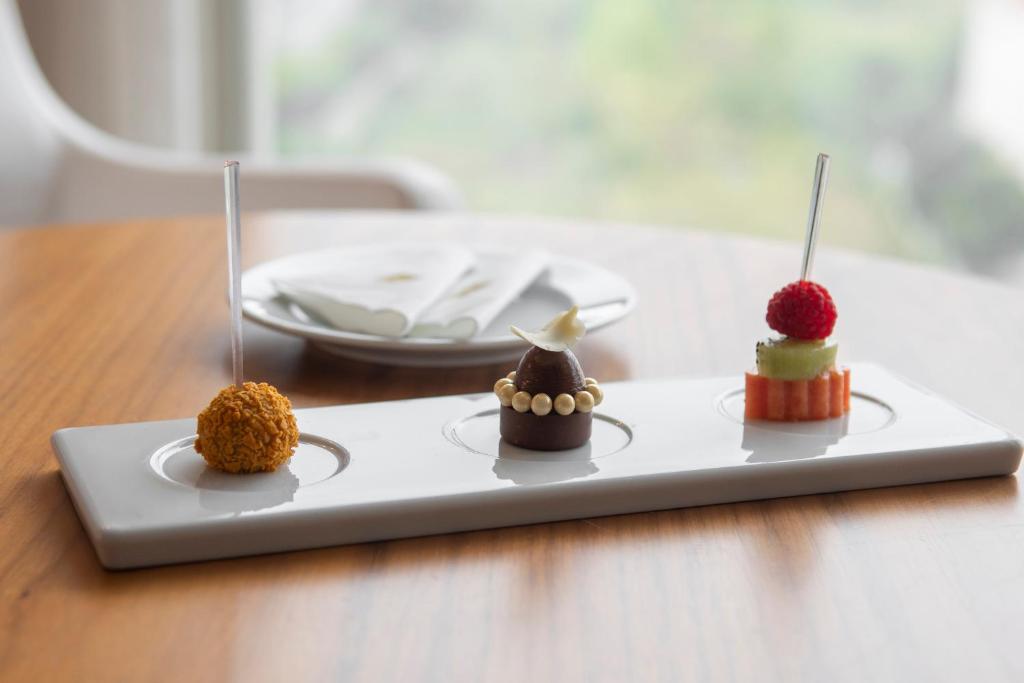 A close-up of three plated bite-size desserts on a restaurant table.