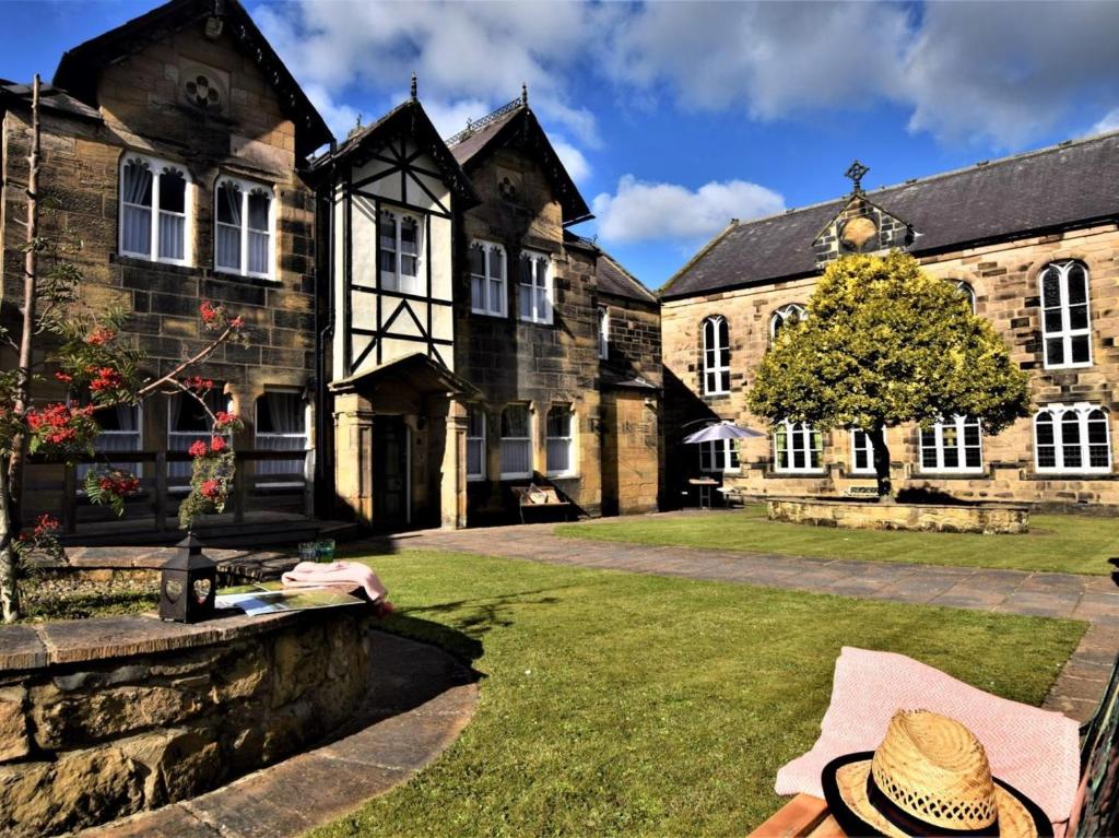a man sitting on a bench in front of a building at 5 Bed in Alnwick oc-60497 in Alnwick