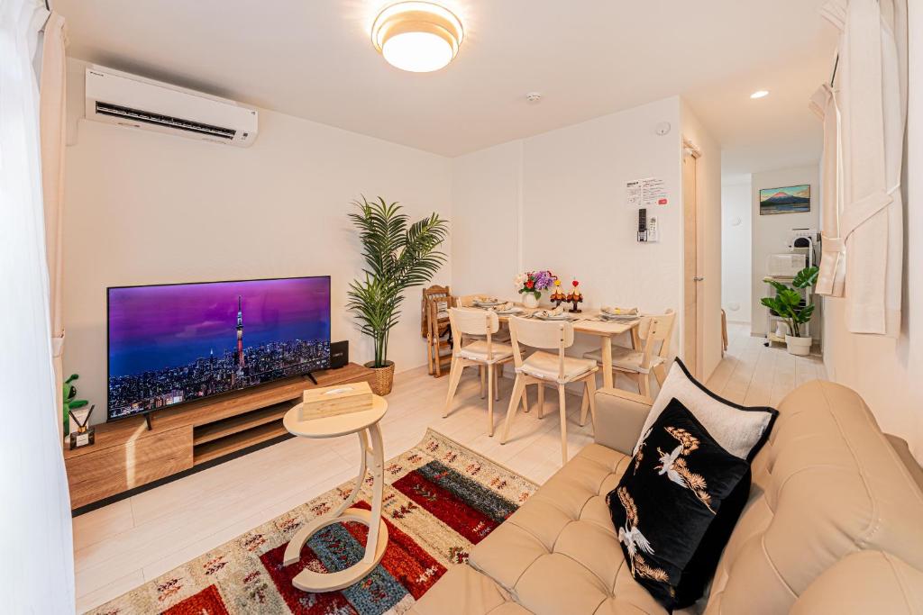 a living room with a couch and a large tv at 春日居 Kasuga House in Tokyo