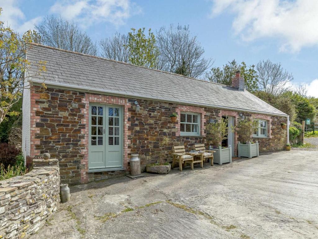 a brick building with a blue door and benches outside at 2 Bed in Wadebridge oc-82681 in Little Petherick
