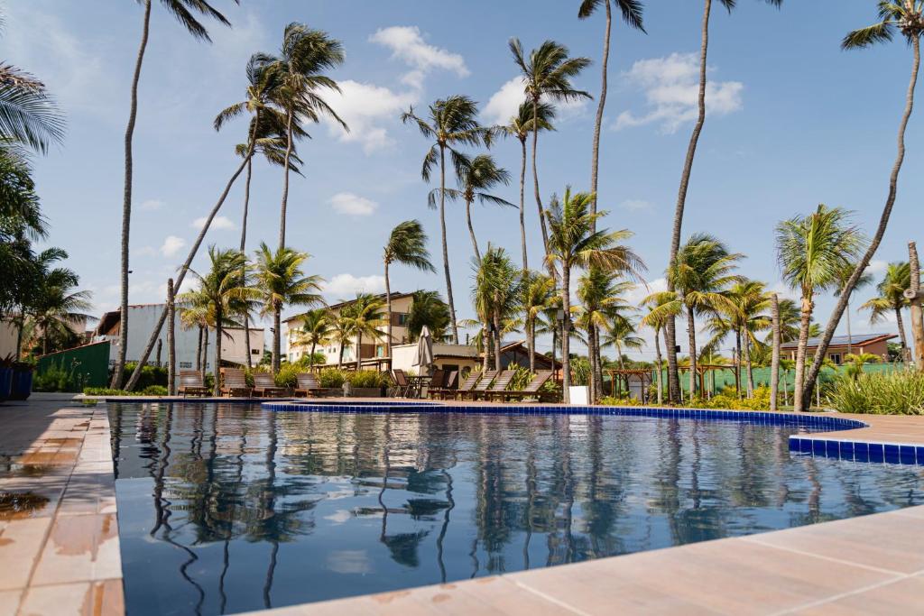 a pool at the resort with palm trees at Isla Beach Hotel in Pecém