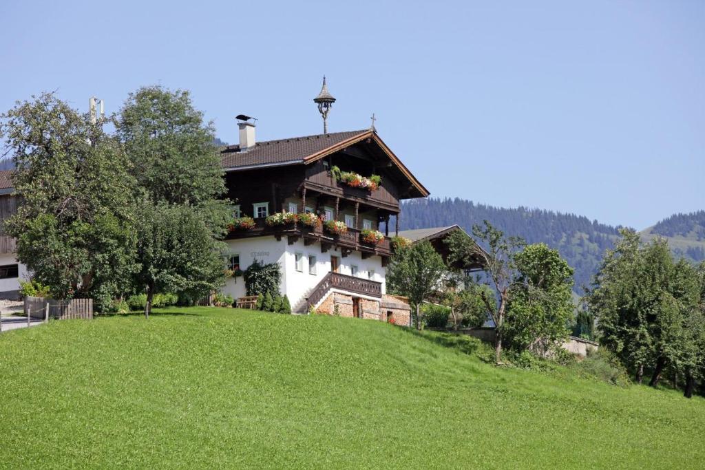 ein Haus auf einem Grashügel in der Unterkunft Bauernhof Mödling in Hopfgarten im Brixental