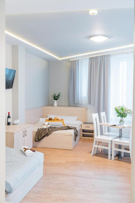 a bedroom with two beds and a table and chairs at S12 Boutique Residence - by Hosty in Krakow