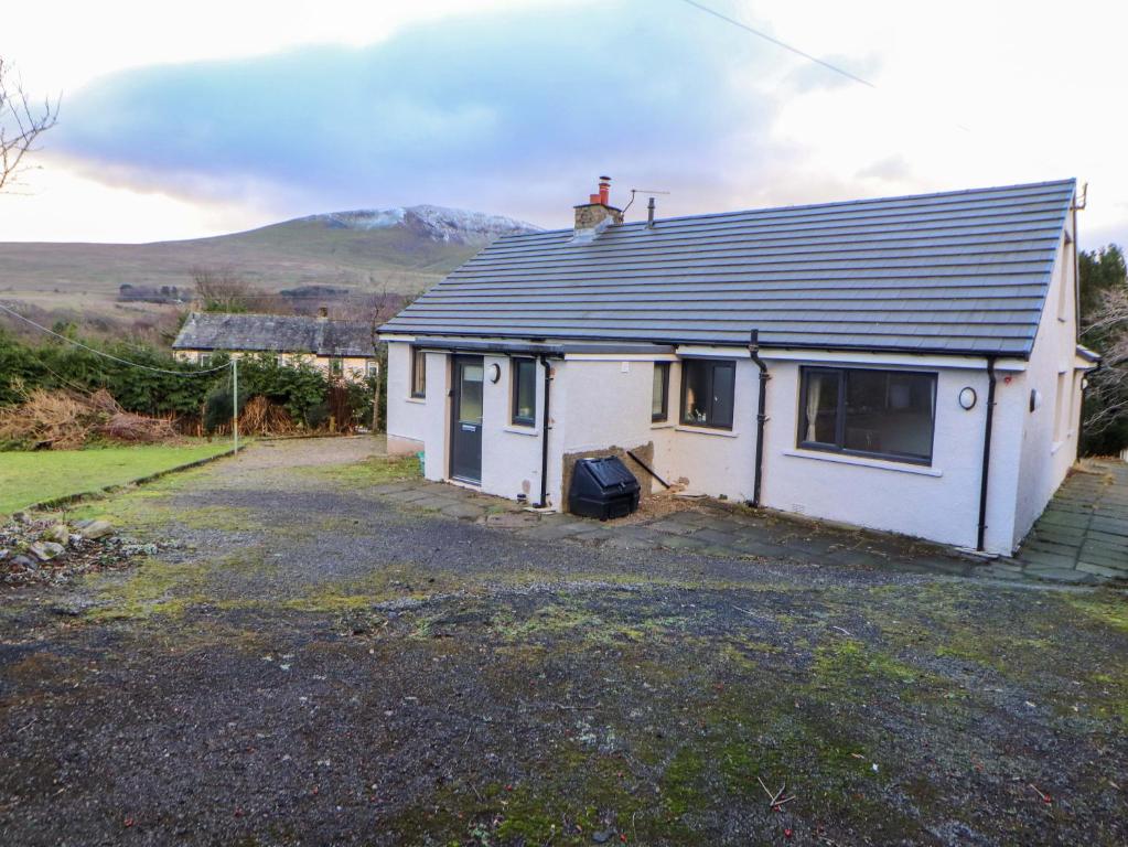 a white house with a mountain in the background at Westerlodge in Keswick