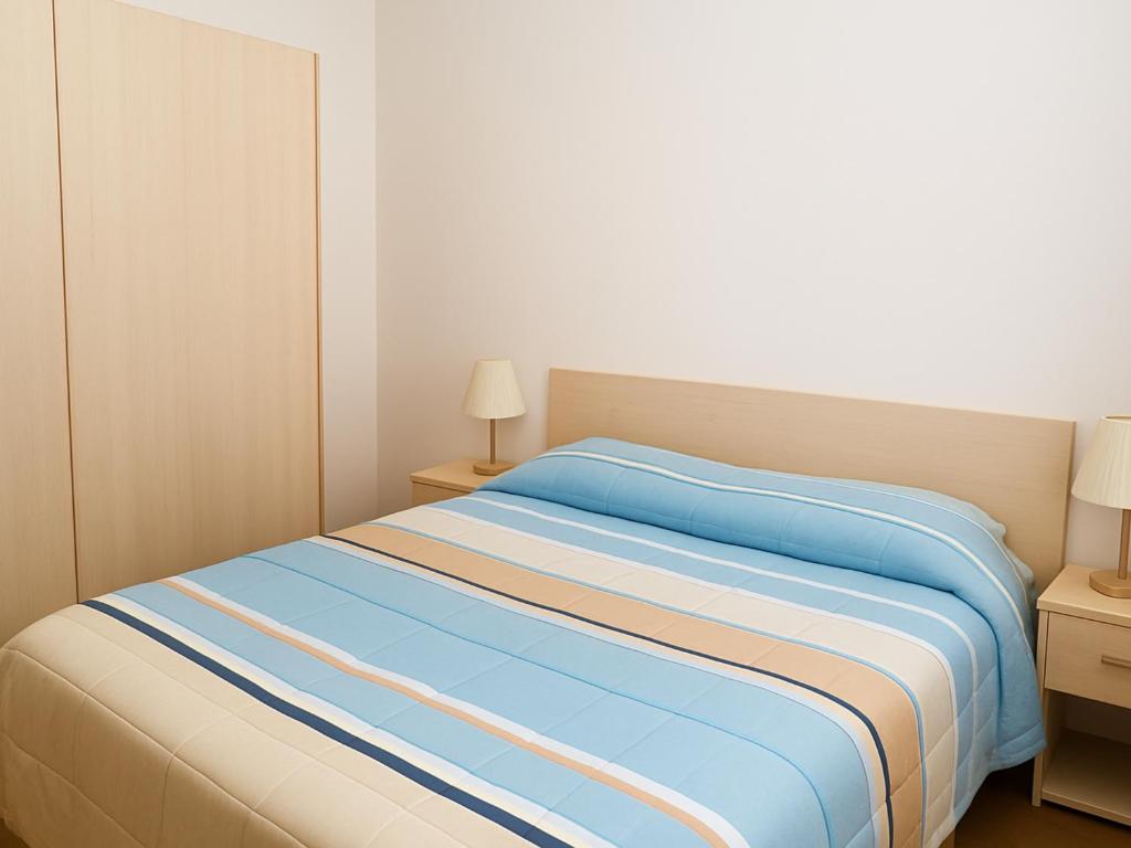 a bedroom with a bed with blue and white sheets at Dimora del Golfo in Soverato Marina