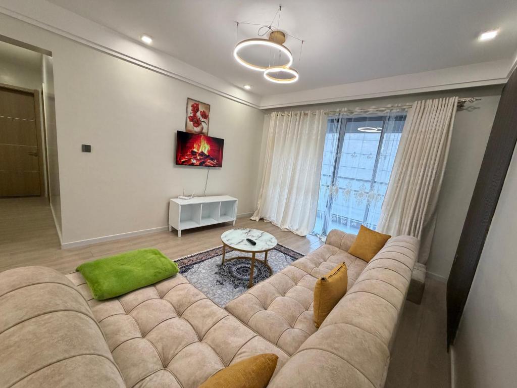 a living room with a large couch and a large window at Ww homes 2bedroom Apartment in Nairobi