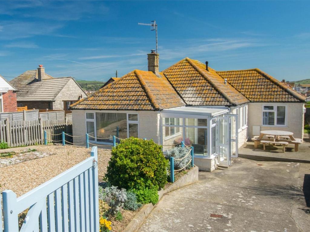 a white house with a fence in front of it at 3 Bed in Bridport oc-dc117 in West Bay