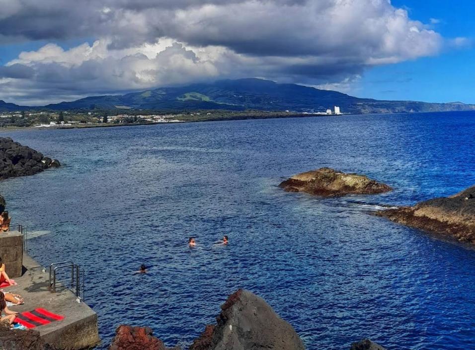two people swimming in a large body of water at Casa do Portinho - Sea View House - in São Roque