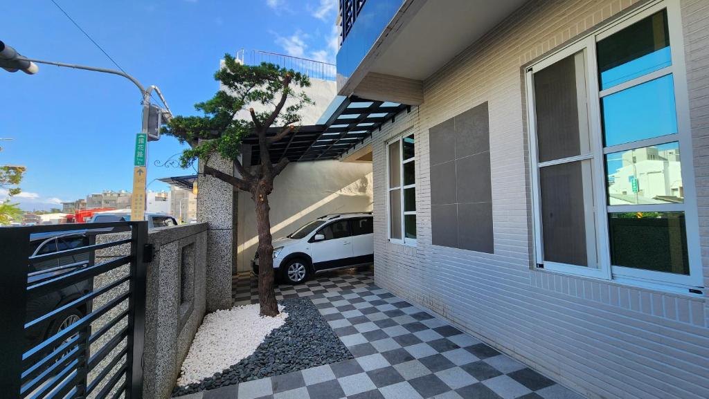 a car parked next to a house with a checkered floor at Dongle B&B in Taitung City