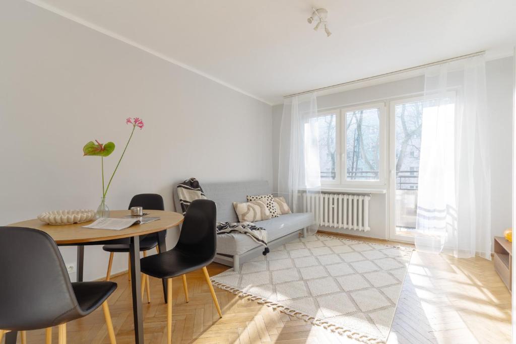 a white living room with a table and chairs at Quiet Kraków Nest by Siemaszki 41 in Krakow