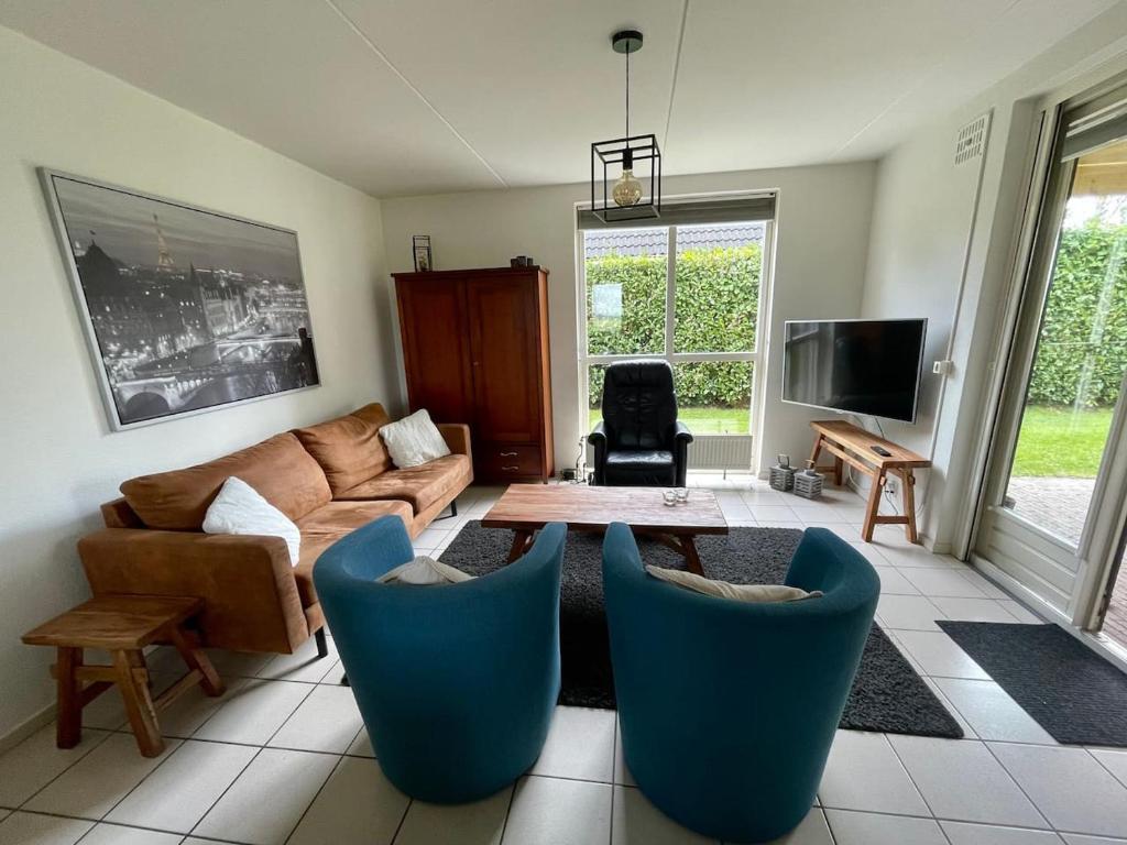 a living room with a couch and a table and chairs at 6 - Persons Forest 223 Bungalow in Ewijk