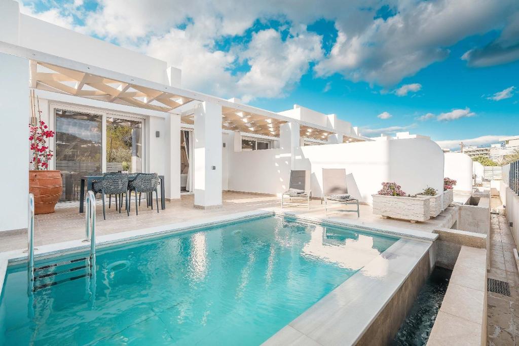 a villa with a swimming pool and a patio at Punta Mare Villas in Karpathos