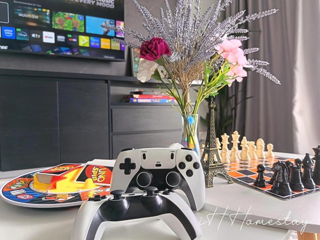 a video game controller sitting on a table with a chess board at Retro Game - D'Lagoon Sri Austin By iH Home in Kempas