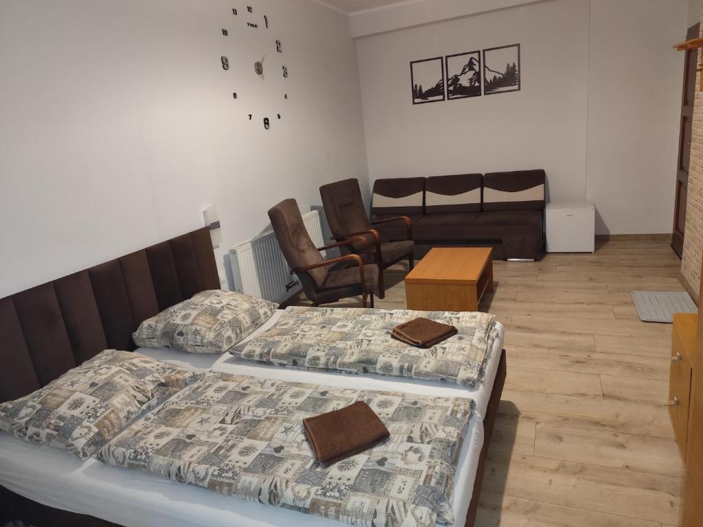 a bedroom with two beds and a living room at Zajazd Kadar in Wisła