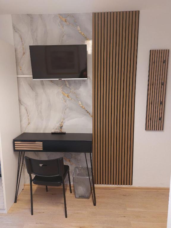 a desk with a monitor and a chair in a room at Pension Alpha in Frankfurt