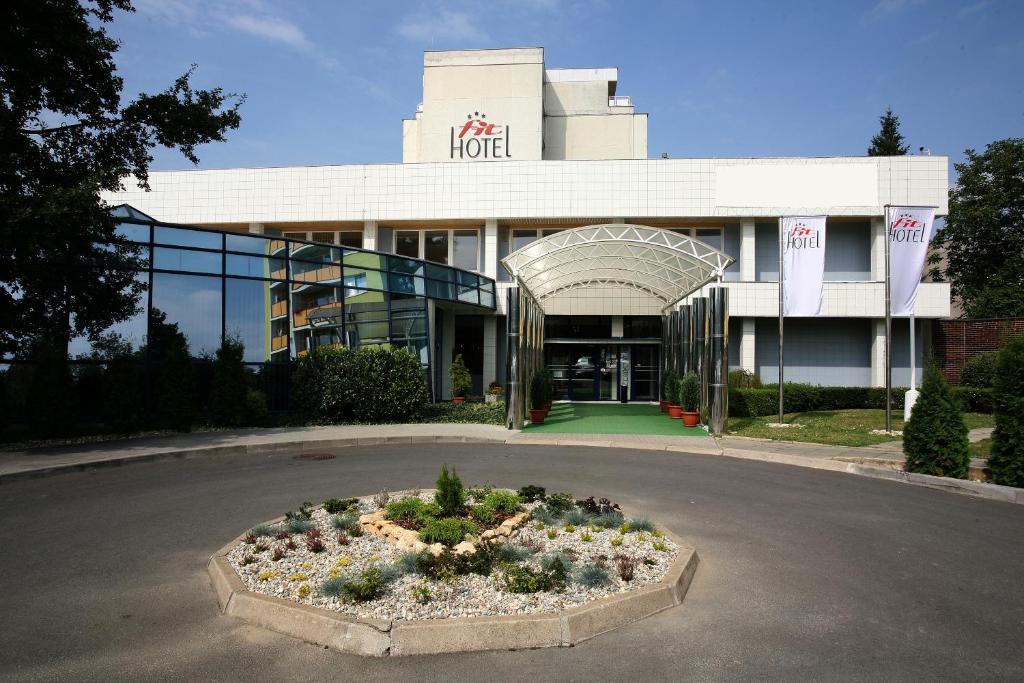 un hotel con un letto a fiori di fronte a un edificio di Hotel FIT a Přerov