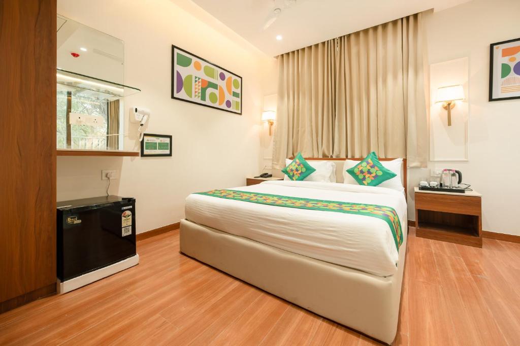 a hotel room with a large bed and a television at Treebo Premium Bizz in Ahmedabad