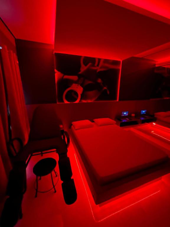 a red room with a bed and a stool at Luxu's Motel in Tucano