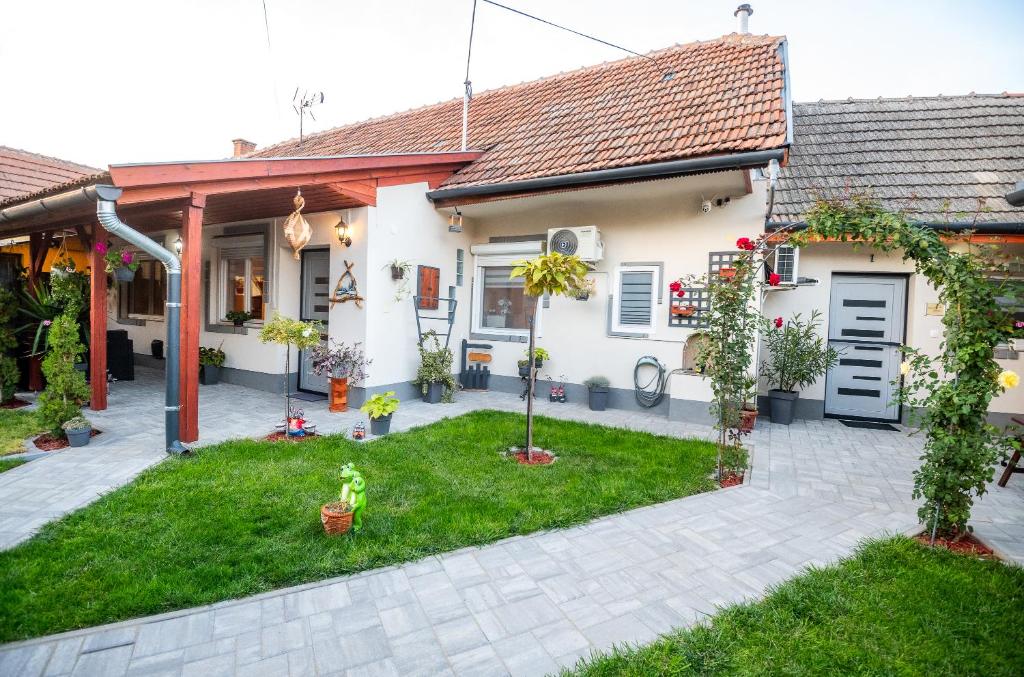 a house with a courtyard with plants and trees at Royal Gold Apartman in Kiskunhalas