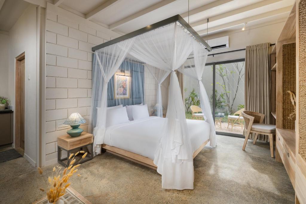 a bedroom with a white bed with a canopy at Chaparrals Surf in Dickwella