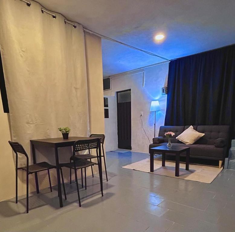 a living room with a table and chairs and a couch at Cómodo departamento en zona céntrica de Puebla in San Baltasar