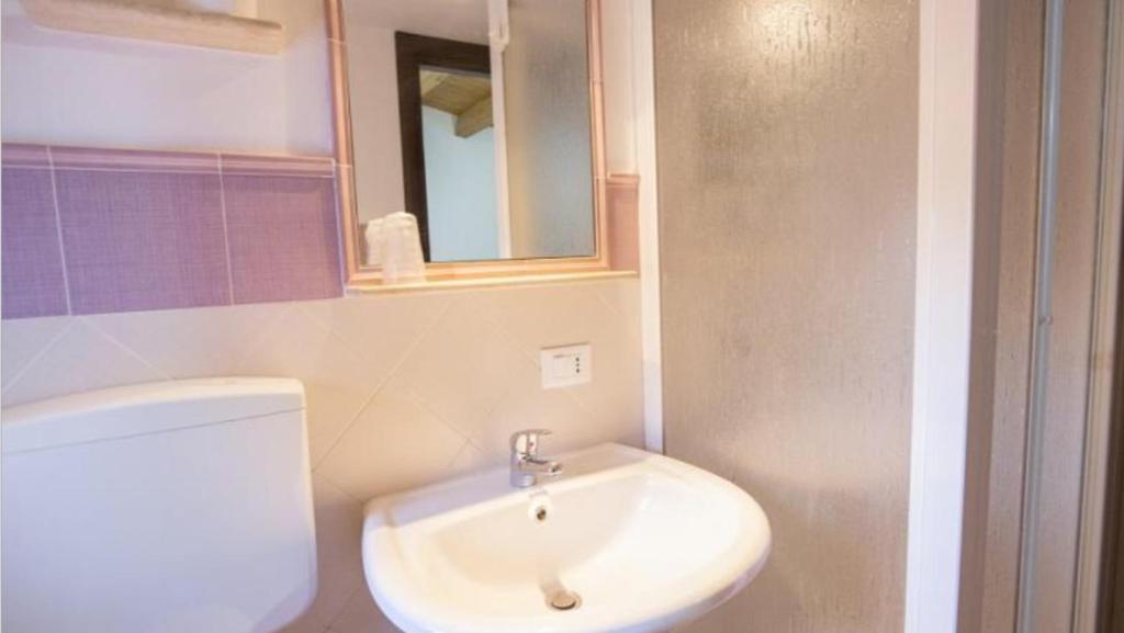 a bathroom with a toilet and a sink and a mirror at Casa Andrea in Cefalù
