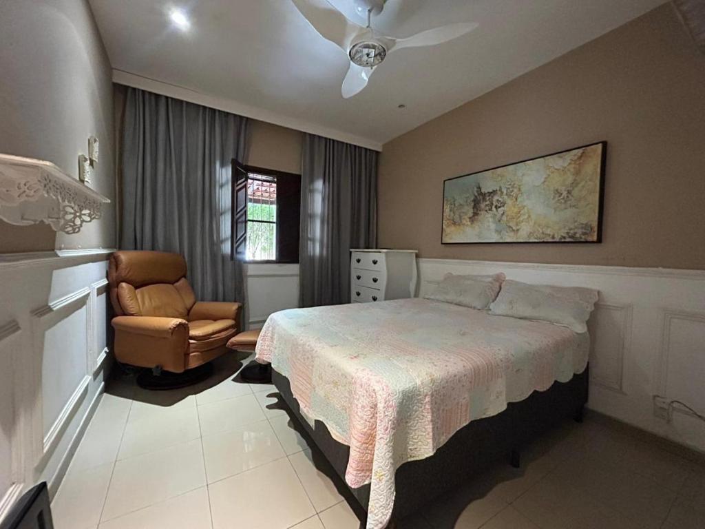 a bedroom with a bed and a chair at Casa Gabo in Serra