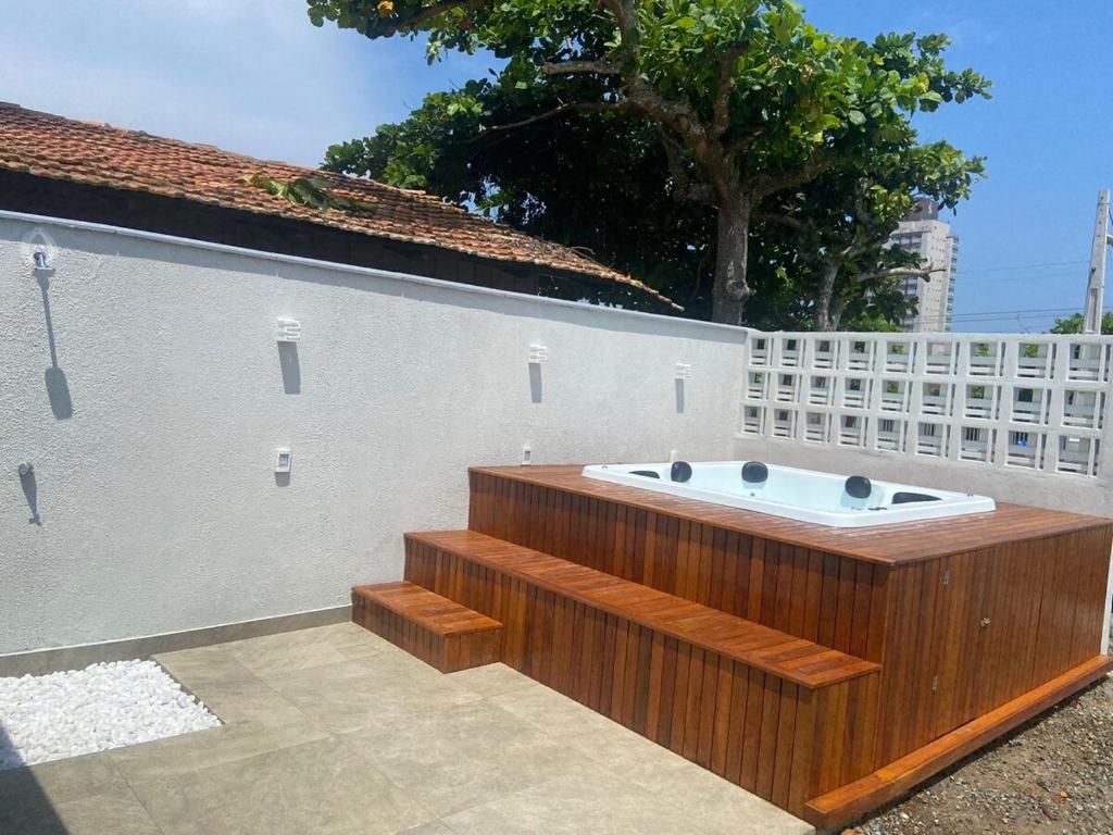 a bath tub sitting next to a white wall at Casa com Spa aquecido em Itajuba in Barra Velha