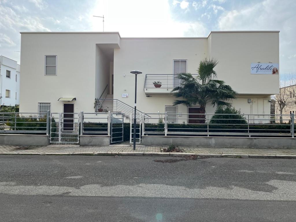 a white building with a staircase in front of it at Afrodite Affittacamere in Metaponto