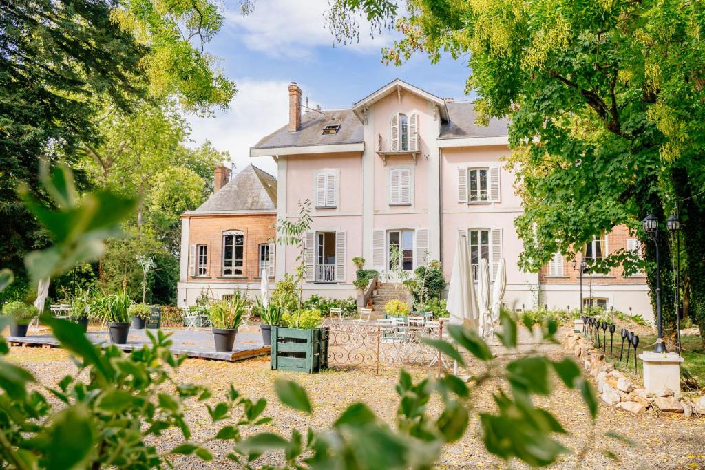 a large pink house with trees in front of it at Château de la Tourlandry in Chemillé